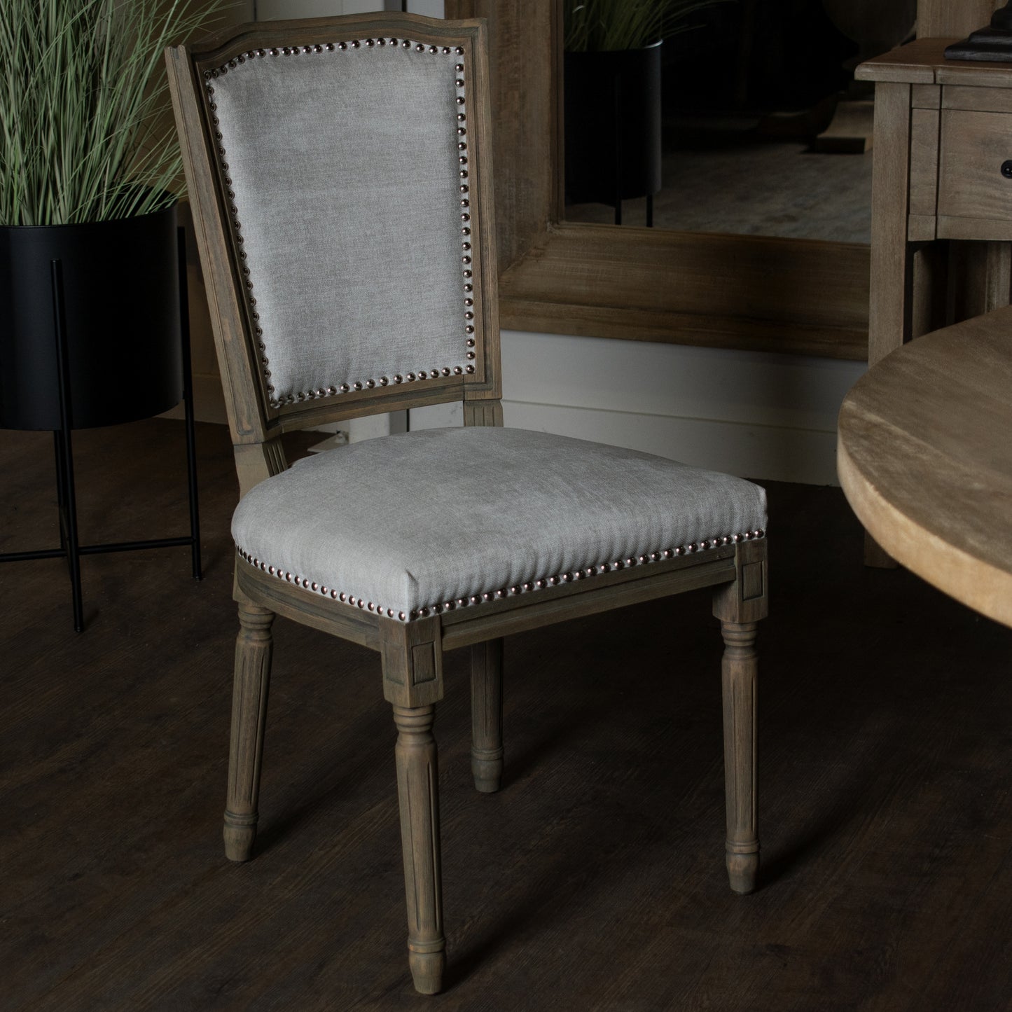 Angle view of Hill Interiors Ripley grey dining chair highlighting the carved frame details