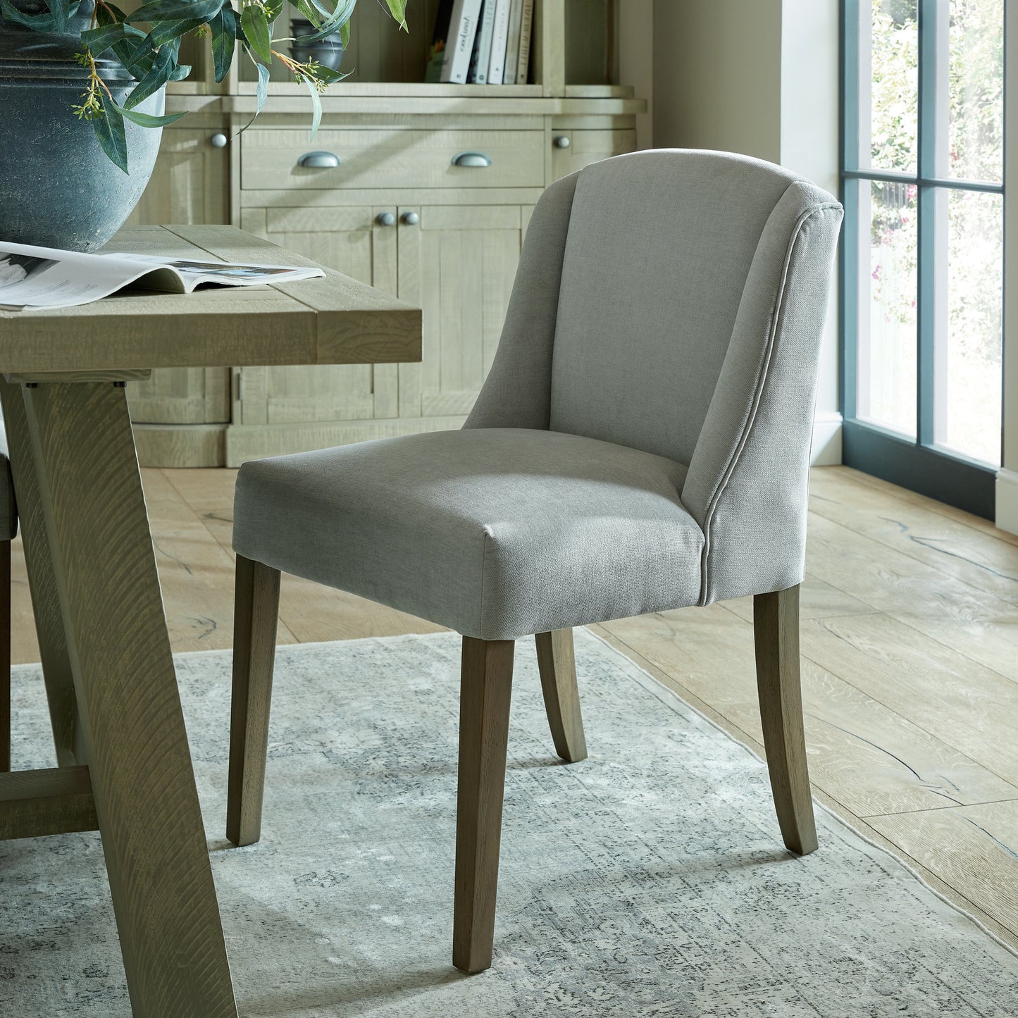 Hill Interiors Compton grey dining chair styled with modern tableware on a dining table