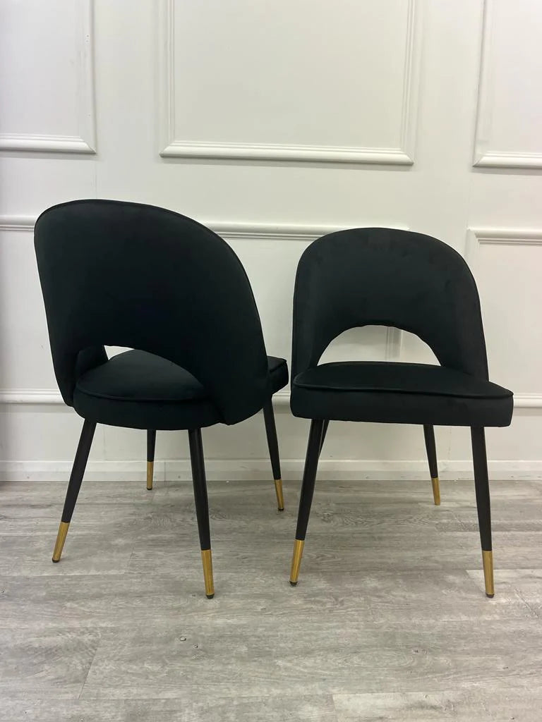 Furnish365 Astra black velvet dining chair with curved open back and gold tipped legs in a contemporary dining setting