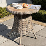 Hill Interiors Amalfi Collection outdoor bistro table with wood top and metal frame in a modern garden setting