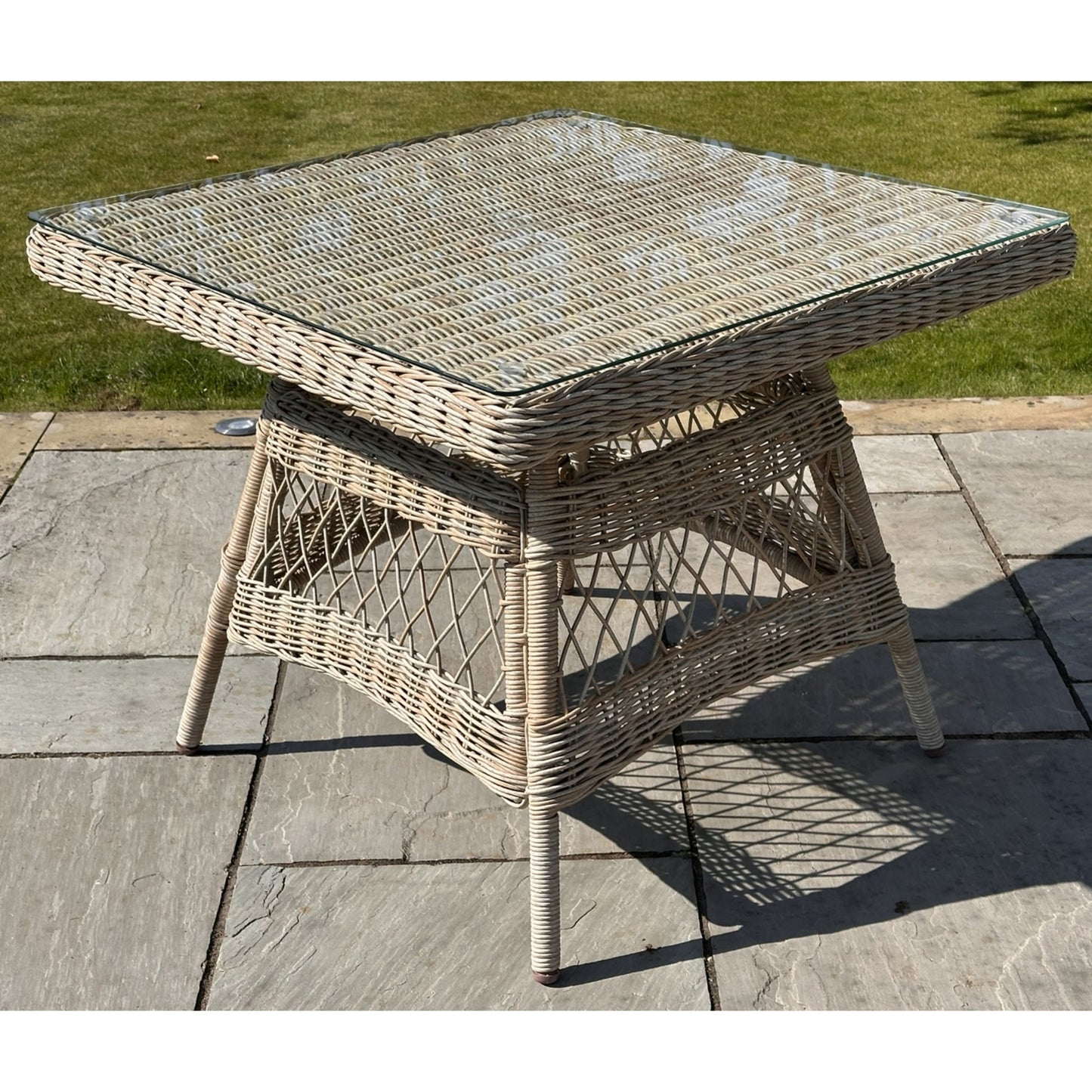 Hill Interiors Provence Collection outdoor 4 seater dining set with beige chairs and glass table in a modern garden setting