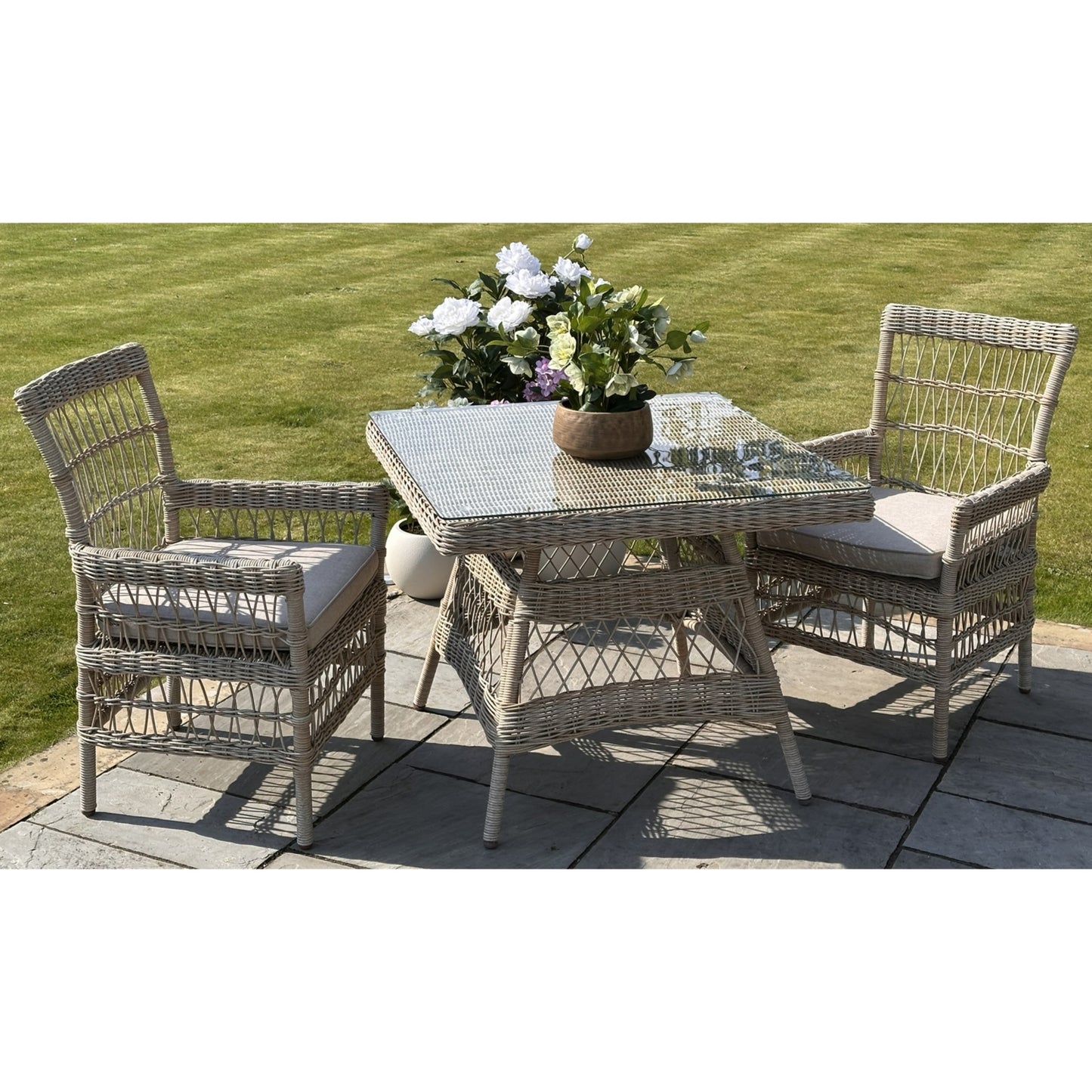 Hill Interiors Provence Collection outdoor 4 seater dining set with beige chairs and glass table in a modern garden setting
