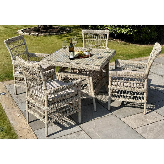 Hill Interiors Provence Collection outdoor 4 seater dining set with beige chairs and glass table in a modern garden setting