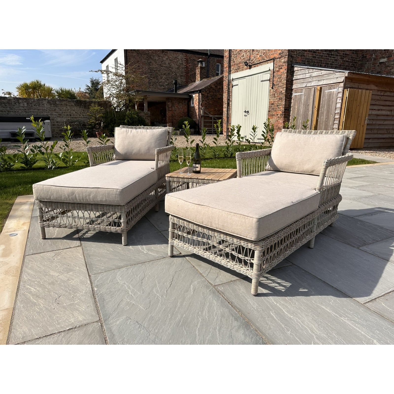 	Side view of Hill Interiors Provence outdoor sun lounger showing the beige fabric and metal frame