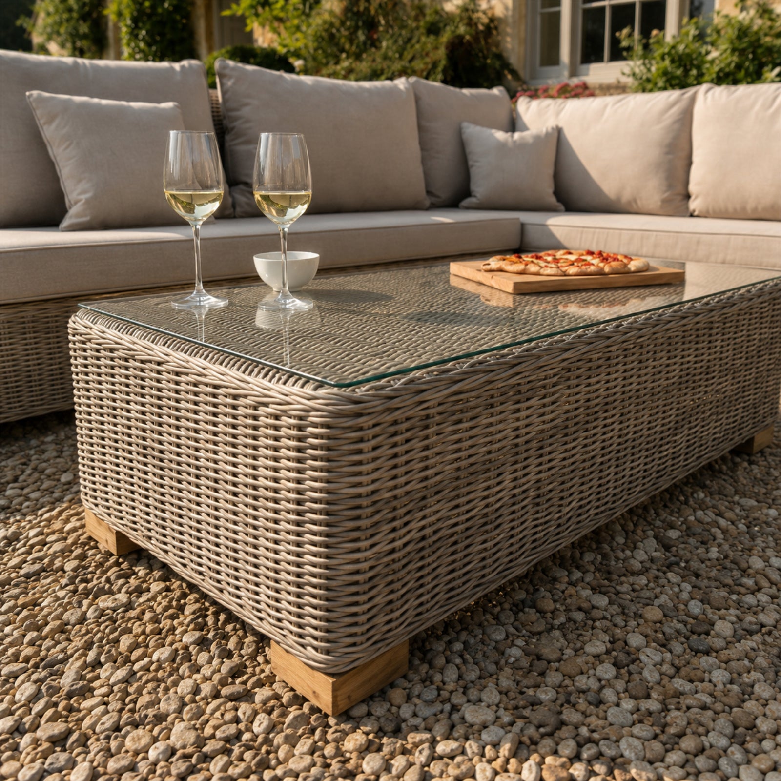 Hill Interiors Capri Collection beige outdoor large corner and coffee table set in a modern garden setting