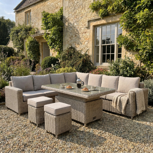 	Hill Interiors Amalfi large outdoor corner set with riser table and 2 stools in beige fabric in a modern garden setting