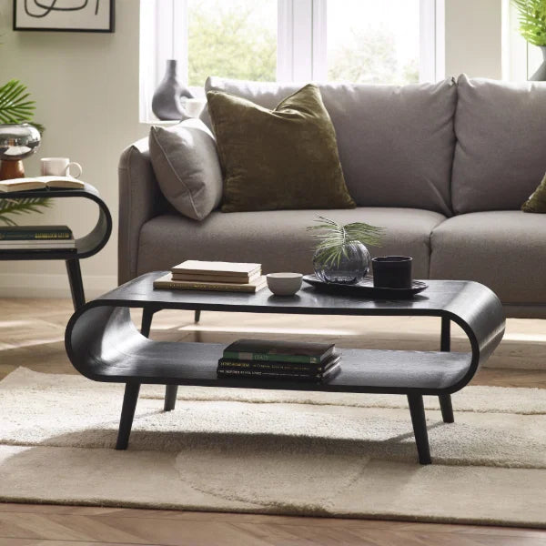 	Apollo black ash coffee table with curved silhouette in a modern Scandinavian living room setting
