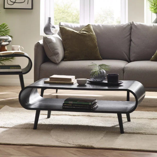	Apollo black ash coffee table with curved silhouette in a modern Scandinavian living room setting
