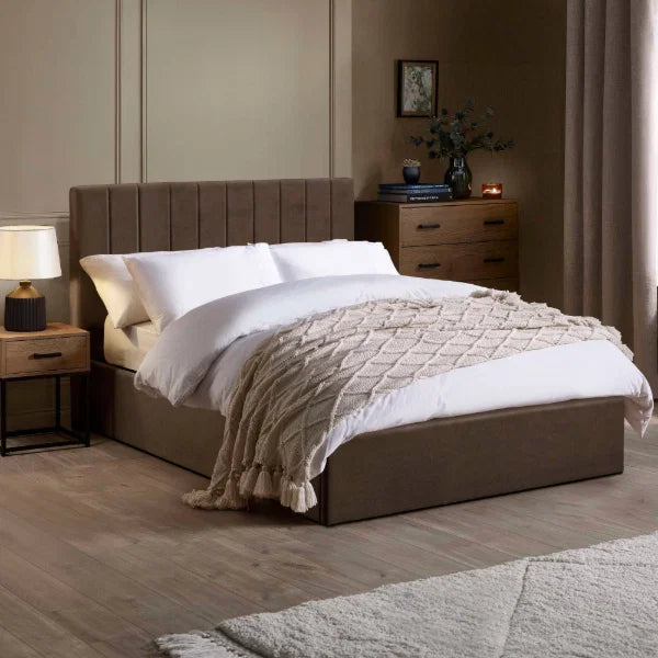 Aylen chocolate velvet ottoman storage bed with panelled headboard in a modern bedroom setting