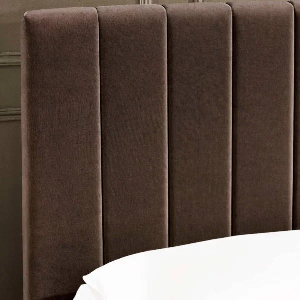 Aylen chocolate velvet ottoman storage bed with panelled headboard in a modern bedroom setting