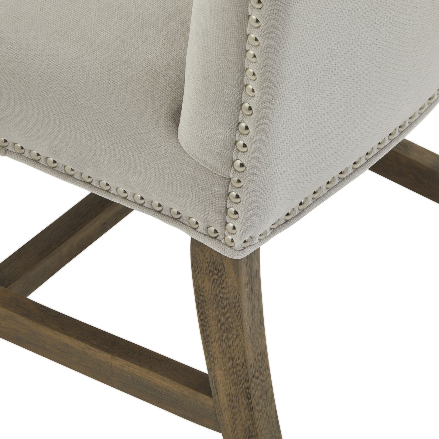 	Angle view of Hill Interiors Cobham grey dining chair highlighting the antique brass studs along the front edge