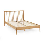 Belton natural oak spindle double bed with tapered legs in a modern bedroom setting
