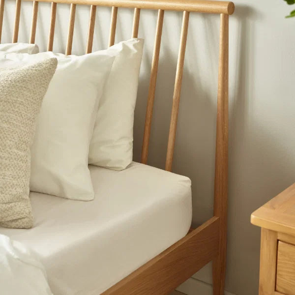 Belton natural oak spindle double bed with tapered legs in a modern bedroom setting
