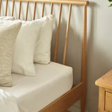 Belton natural oak spindle double bed with tapered legs in a modern bedroom setting