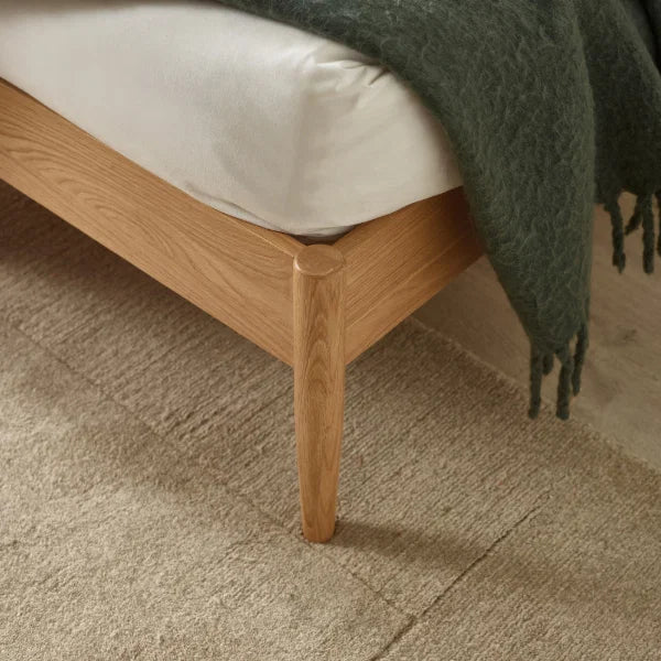 Belton natural oak spindle double bed with tapered legs in a modern bedroom setting