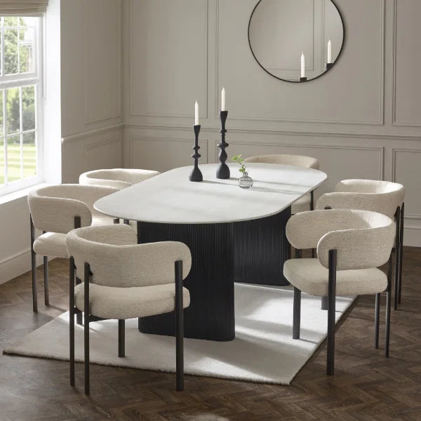 Bolivia oval marble-effect dining table with white glass top and fluted black pedestal legs in a modern dining room setting