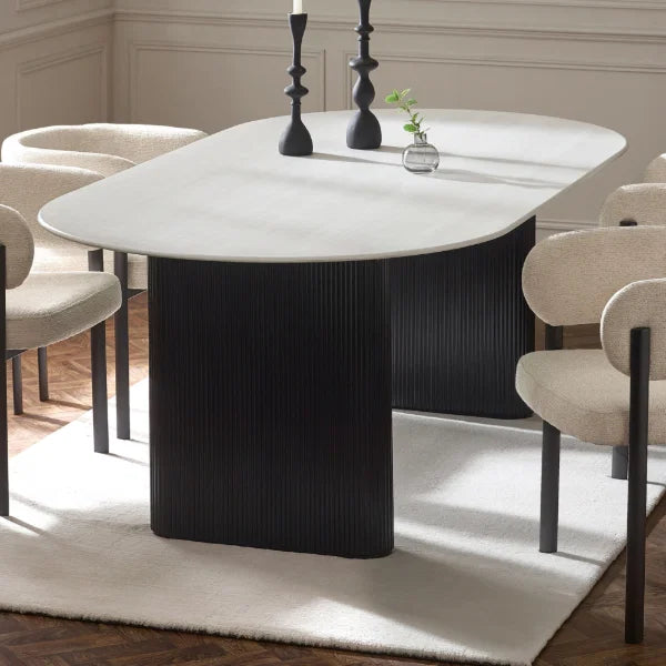 Bolivia oval marble-effect dining table with white glass top and fluted black pedestal legs in a modern dining room setting