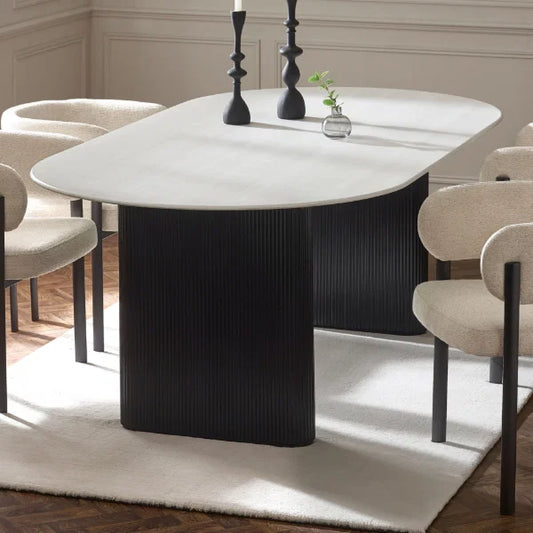 Bolivia oval marble-effect dining table with white glass top and fluted black pedestal legs in a modern dining room setting