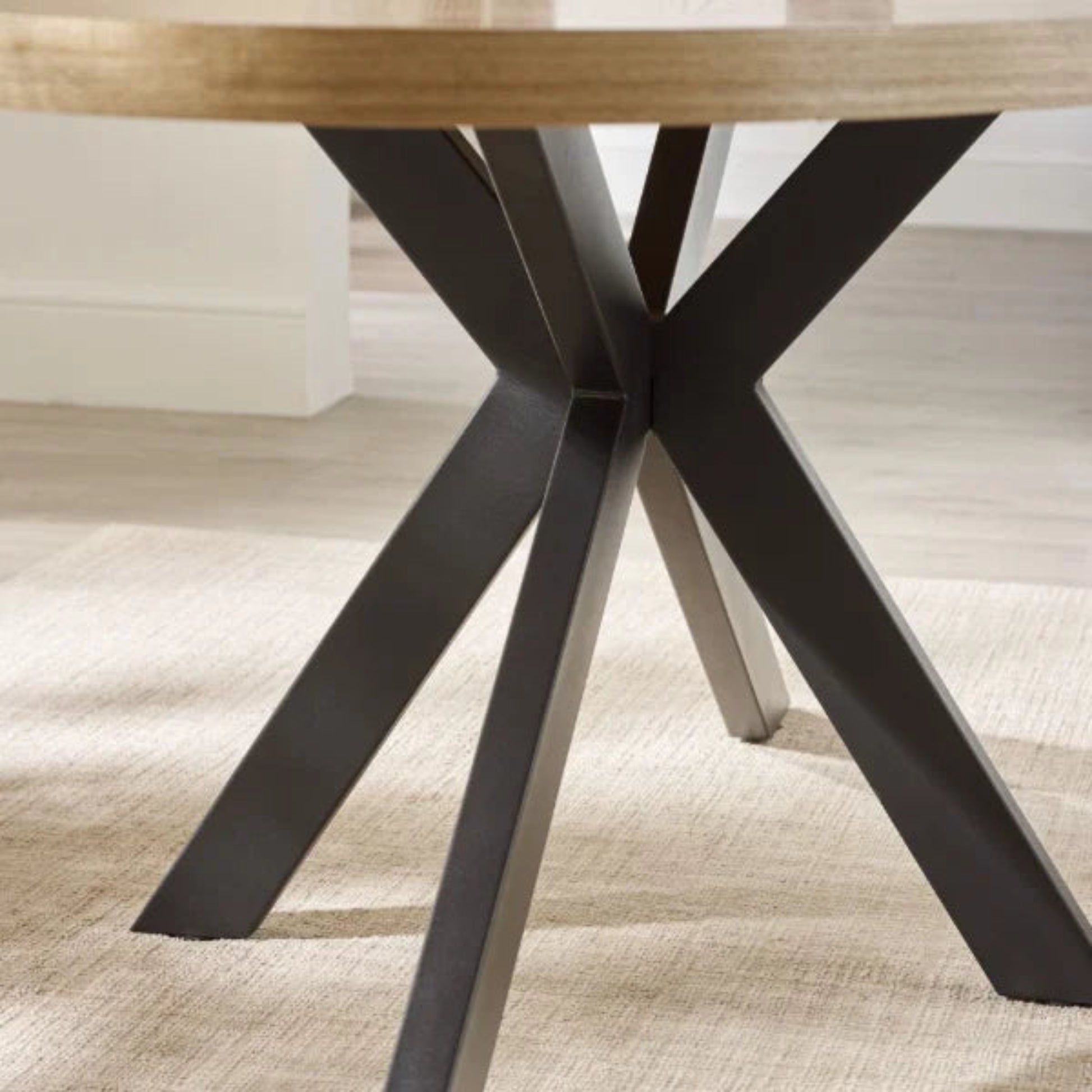 Bondi oval dining table with surfboard-shaped light oak top and black legs in a modern dining setting