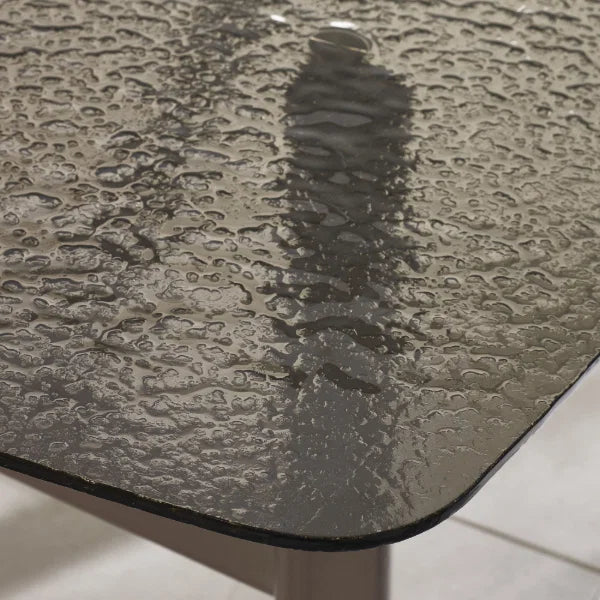 Callisto smoked bubble glass dining table with brushed bronze legs in a modern dining room setting