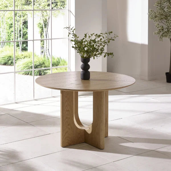Cellini round oak-effect dining table with sculptural intersecting base in a modern dining room setting