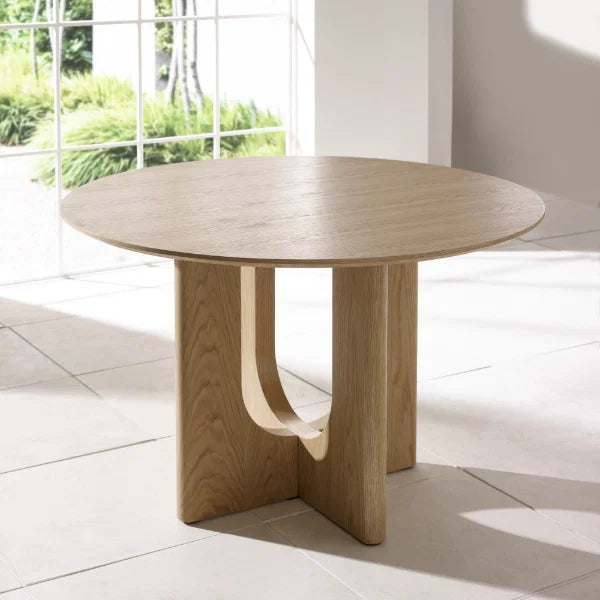 Cellini round oak-effect dining table with sculptural intersecting base in a modern dining room setting