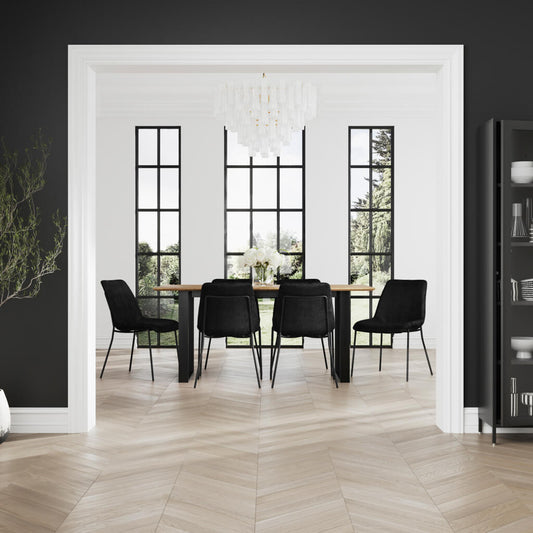 LPD Furniture Carlo black textured velvet dining chair with curved metal back in a modern dining setting