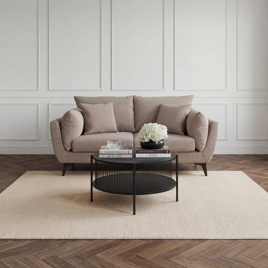 LPD Furniture Carter taupe 2 seater sofa with pillow-shaped design, matte black legs, and scatter cushions in a modern living room setting