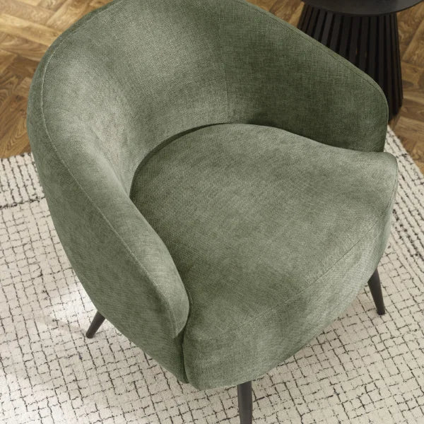 Dahlia olive green accent chair with curved backrest in a modern living room setting