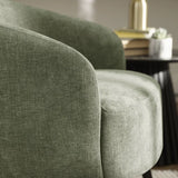 Dahlia olive green accent chair with curved backrest in a modern living room setting