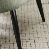 Dahlia olive green accent chair with curved backrest in a modern living room setting