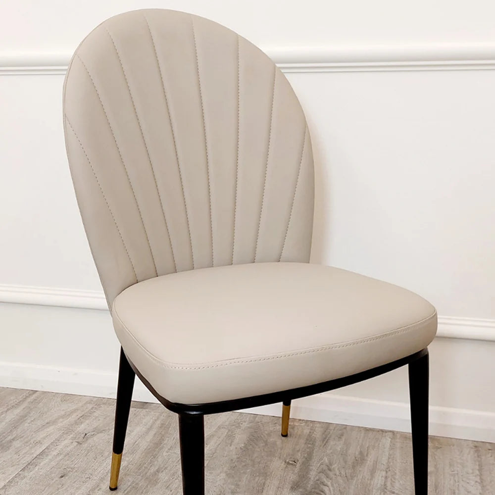 Furnish365 Etta dining chair in soft neutral fabric with curved backrest and gold-tipped legs in a contemporary dining setting