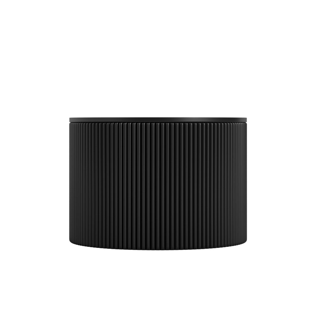 LPD Furniture Eden round black coffee table with textured top and ribbed base in a modern living room setting