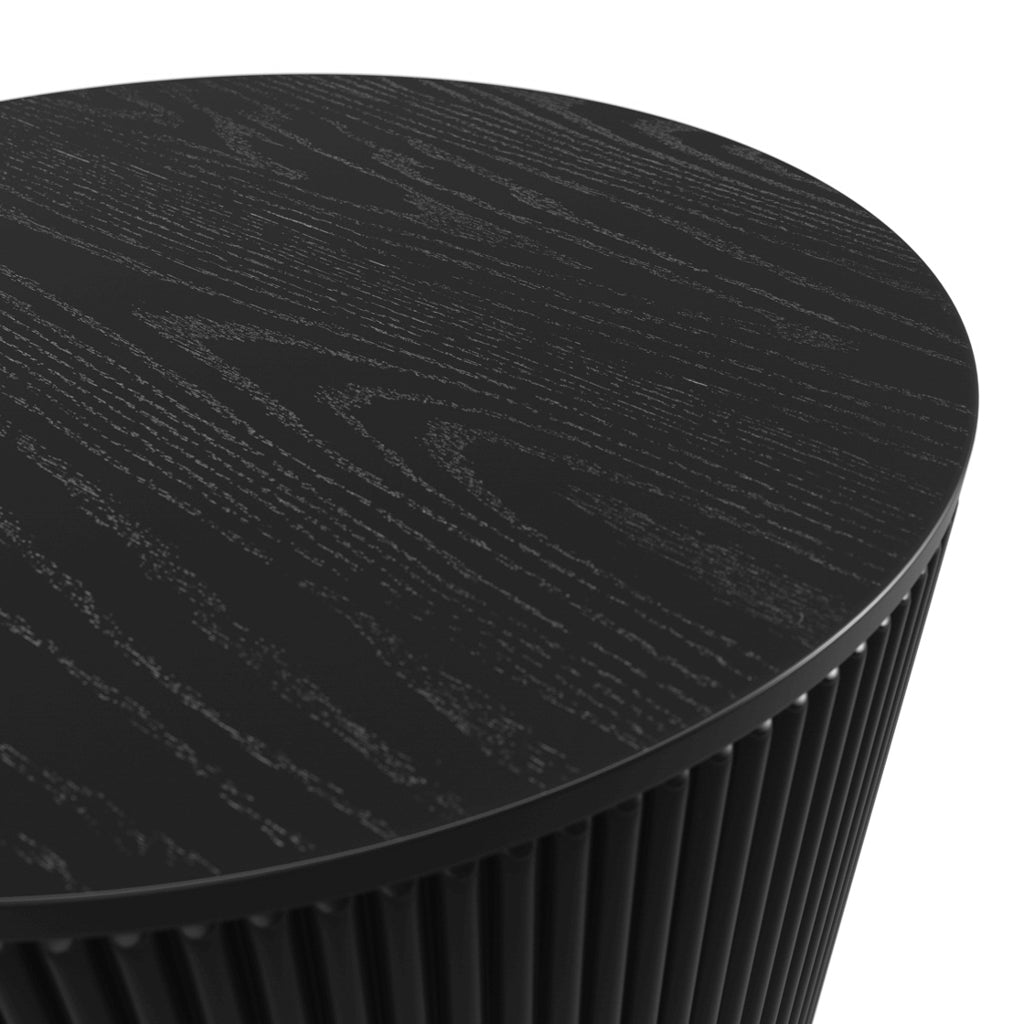 LPD Furniture Eden round black coffee table with textured top and ribbed base in a modern living room setting
