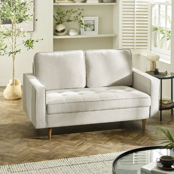 Henrietta beige 2 seater sofa with tufted seat cushions in a modern living room setting