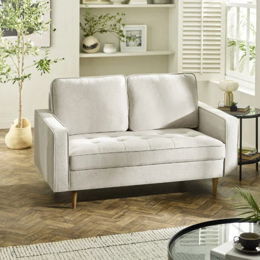 Henrietta beige 2 seater sofa with tufted seat cushions in a modern living room setting