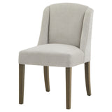	Hill Interiors Compton light grey woven fabric dining chair with sleek contemporary silhouette, placed in a modern dining setting