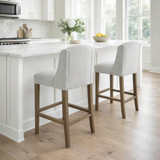 Hill Interiors Compton grey fabric barstool with wooden frame, placed in a modern kitchen setting