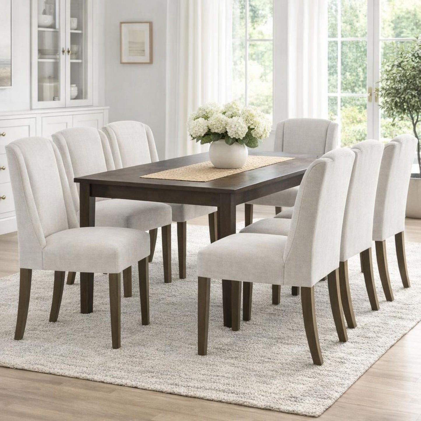 	Hill Interiors Compton light grey woven fabric dining chair with sleek contemporary silhouette, placed in a modern dining setting