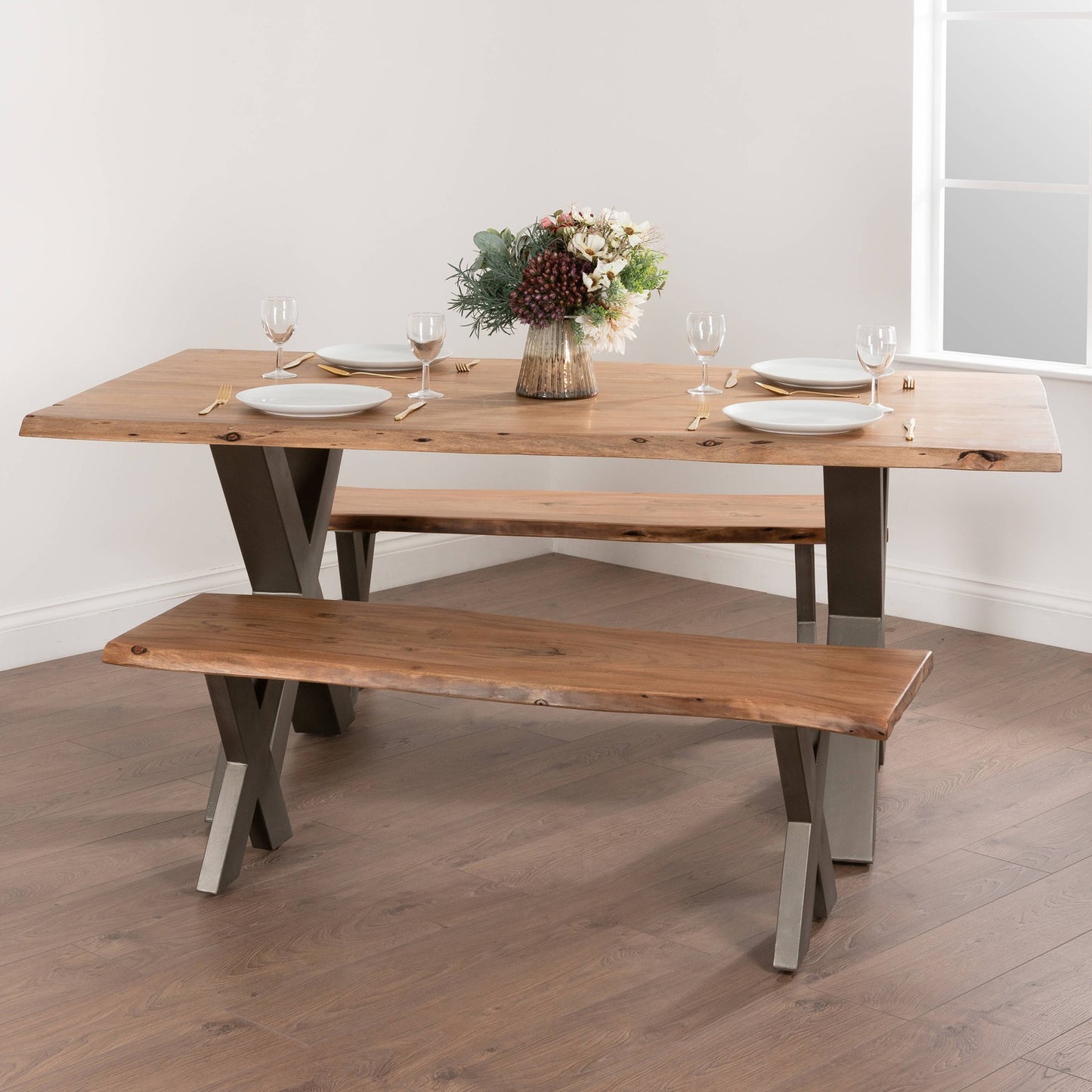 Hill Interiors Live Edge Collection acacia wood bench with grey metal cross-leg frame, placed in a modern dining setting