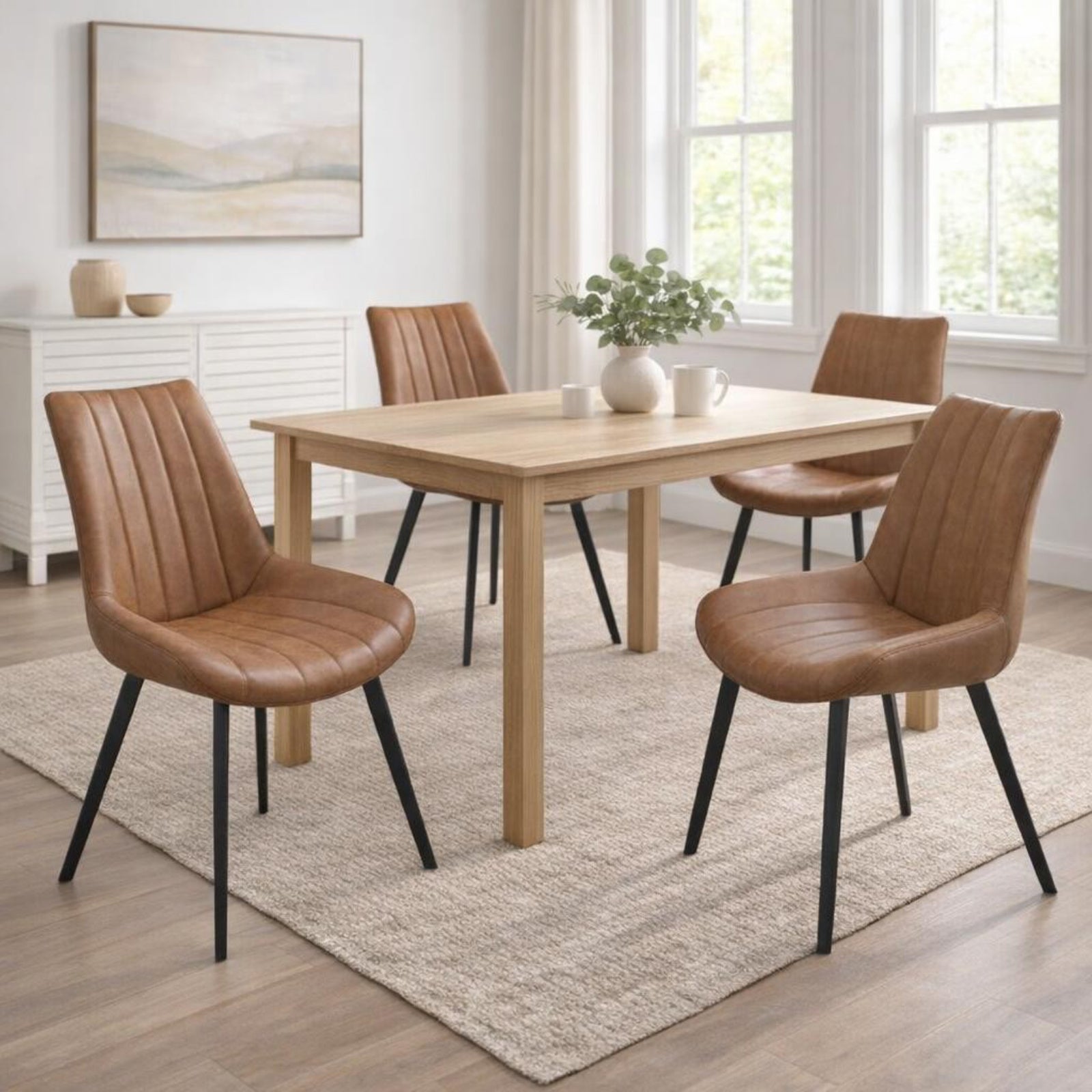 Hill Interiors Malmo tan dining chair with channel-stitched backrest and black metal legs, placed in a modern dining setting