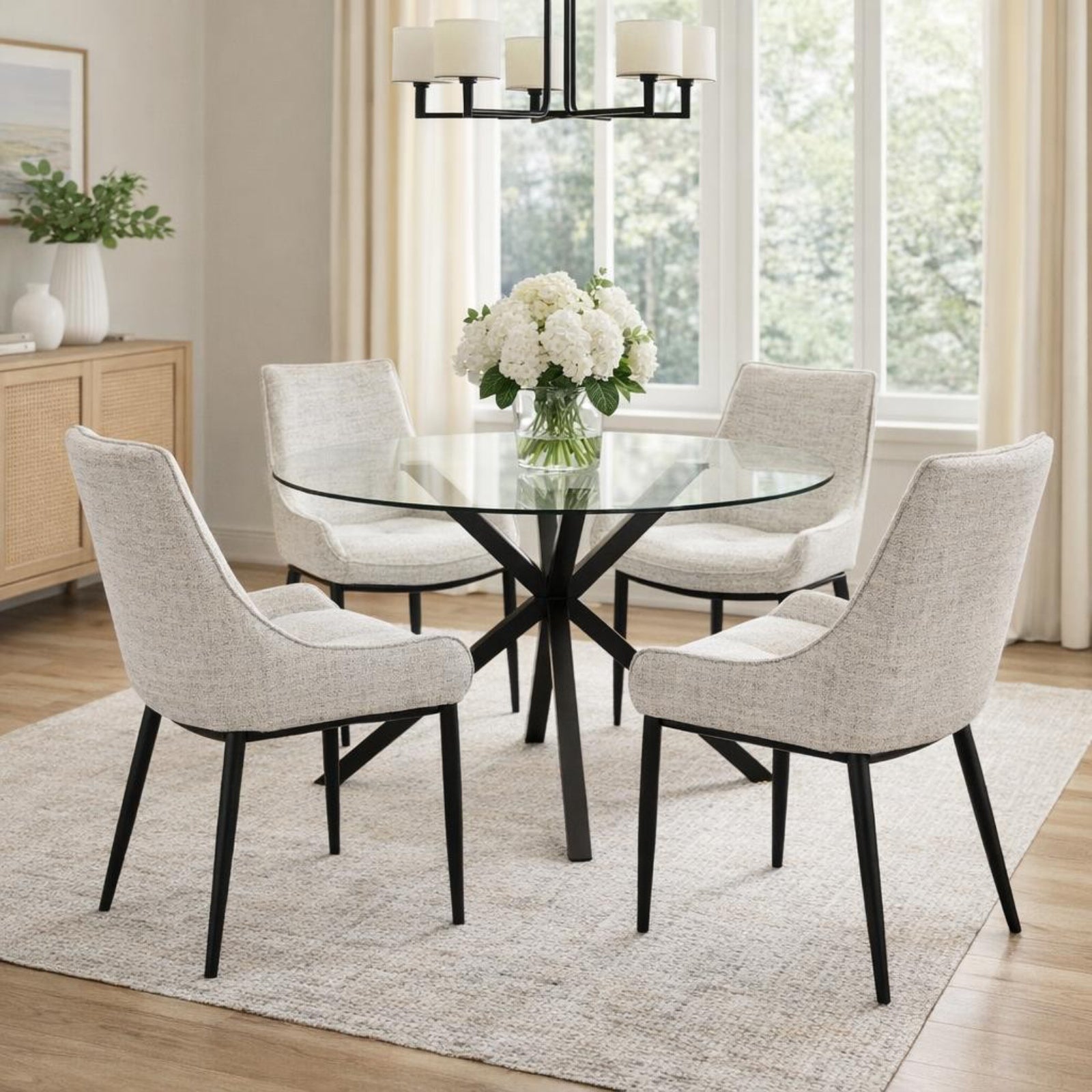 Hill Interiors Monza round glass dining table with chrome base, placed in a modern dining setting