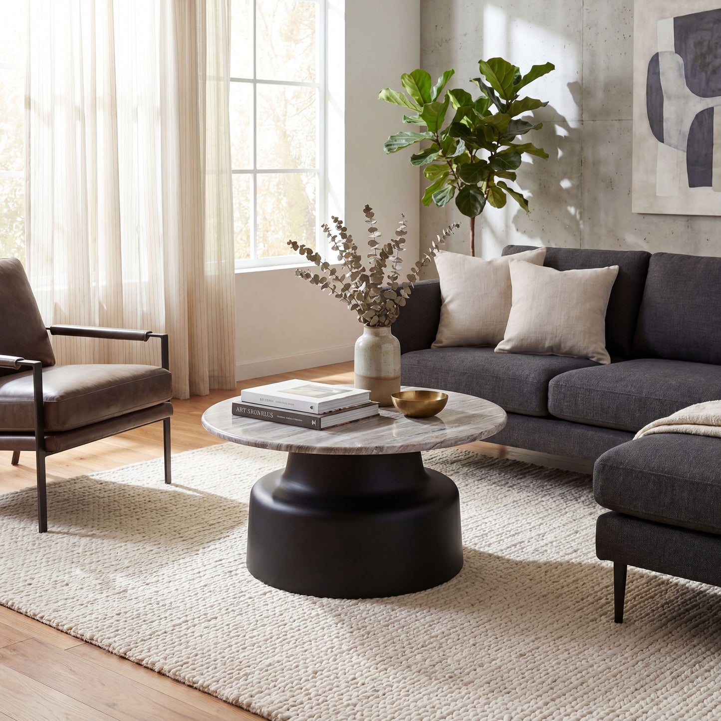 Hill Interiors Oura round coffee table with metal frame and wooden top, placed in a modern living room setting