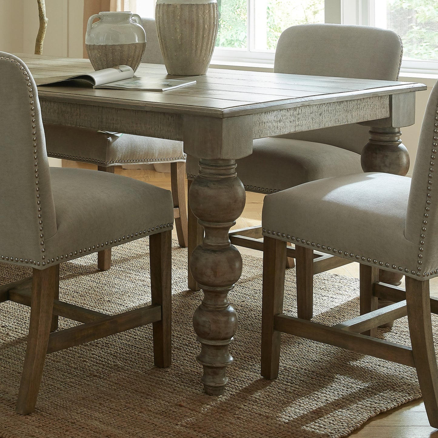 	Hill Interiors Rutland Collection dining table in a formal dining room with elegant chairs and chandelier lighting