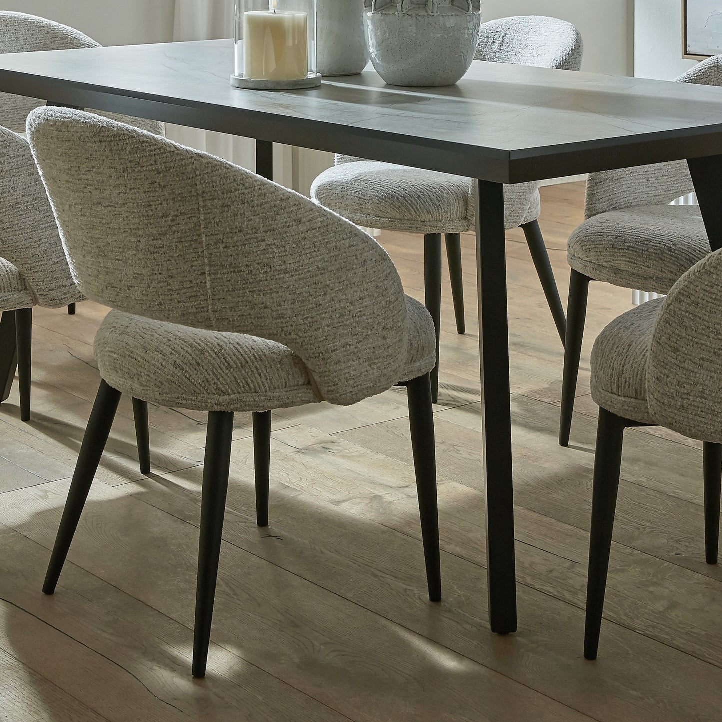 Lifestyle view of Hill Interiors Sorelle curved white dining chair in a stylish contemporary dining space