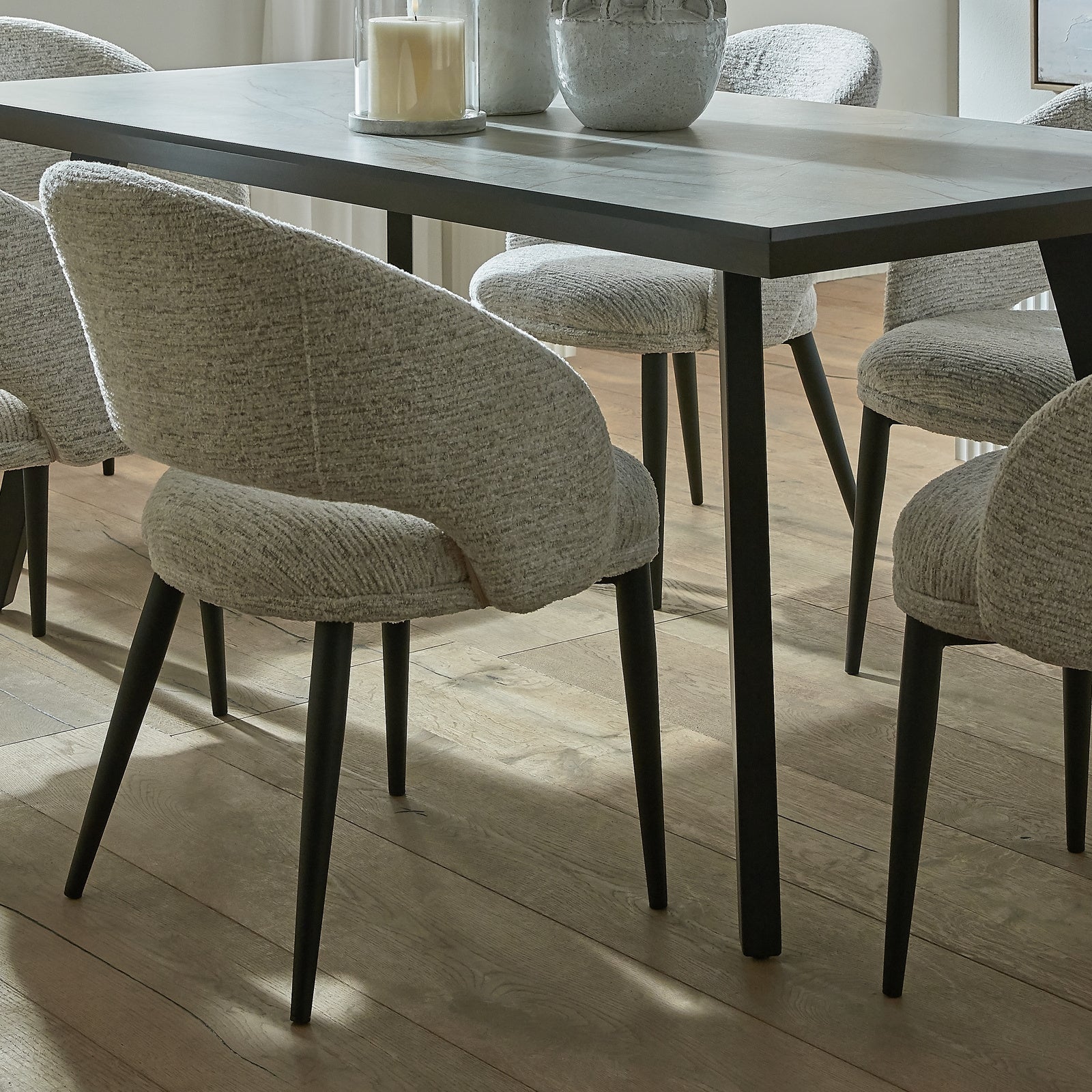 Lifestyle view of Hill Interiors Sorelle curved white dining chair in a stylish contemporary dining space