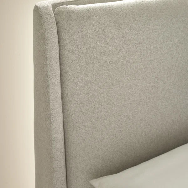 Maddock beige ottoman storage bed with split-panel headboard in a modern bedroom setting
