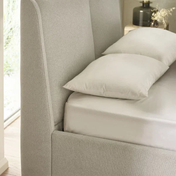 Maddock beige ottoman storage bed with split-panel headboard in a modern bedroom setting