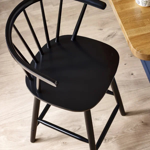Modena black solid wood bar stool with curved spindle back in a modern kitchen setting