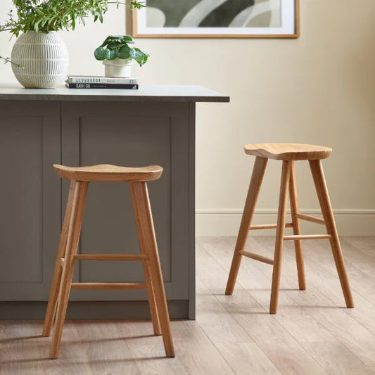 	Mulu natural oak bar stool with saddle seat in a modern kitchen setting